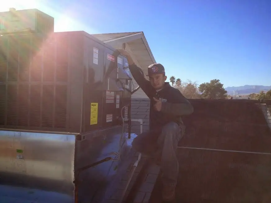 HVAC technician performing AC Tune-Up on a rooftop unit in Sussex
